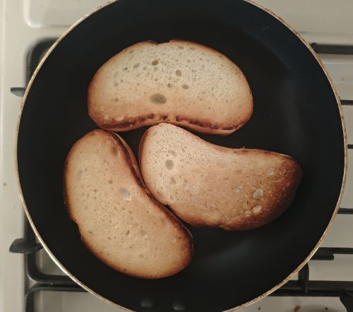 フライパンでフランスパンを焼いている様子